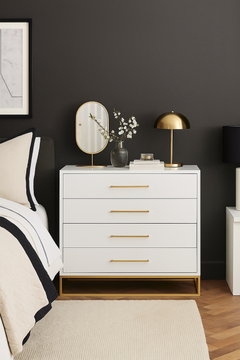 The Verona Chest of 4 Drawers in white with gold handles in a bedroom