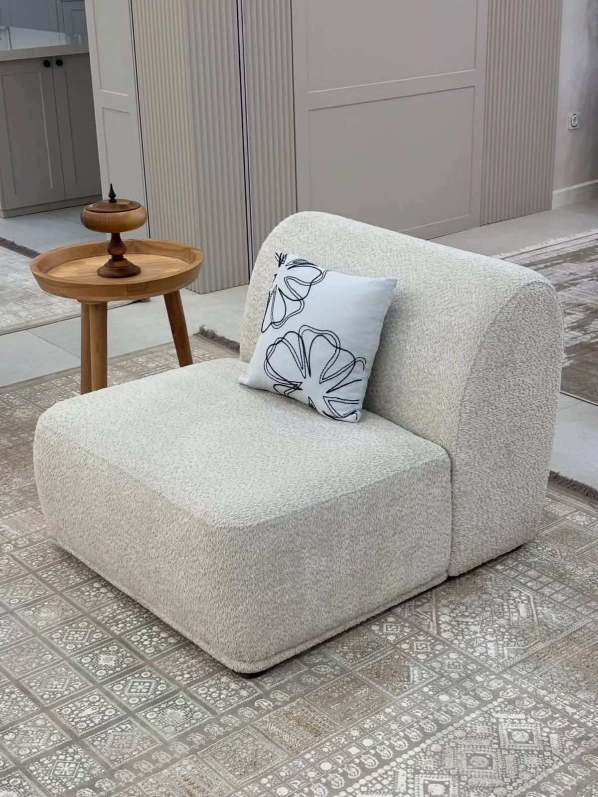Cream bouclé Pebble modular single seater with curved back in a modern living room