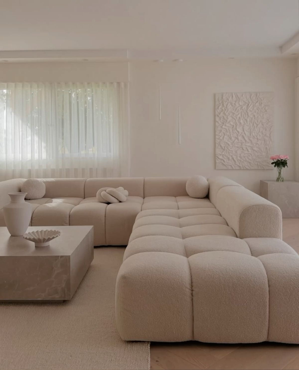 Cream bouclé Cumulus modular sectional in a U-shape configuration in a bright living room