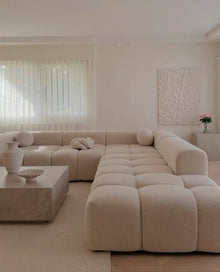 Cream bouclé Cumulus modular sectional in a U-shape configuration in a bright living room
