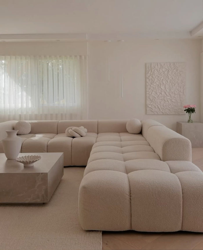 Cream bouclé Cumulus modular sectional in a U-shape configuration in a bright living room