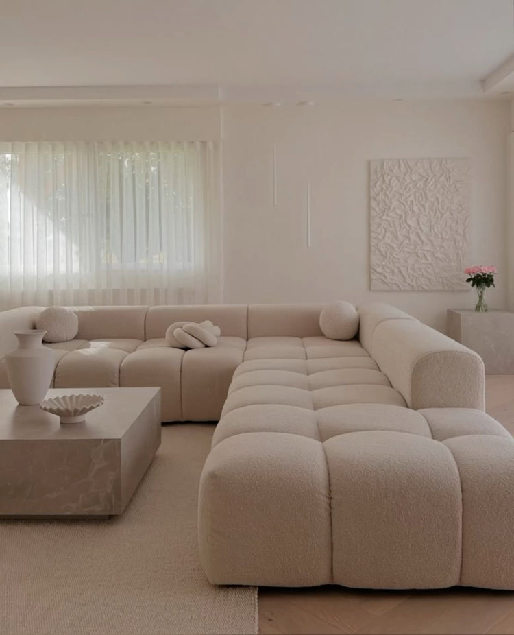 Cream bouclé Cumulus modular sectional in a U-shape configuration in a bright living room
