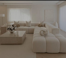 Cream bouclé Cumulus modular sectional seen from the side in a neutral lounge