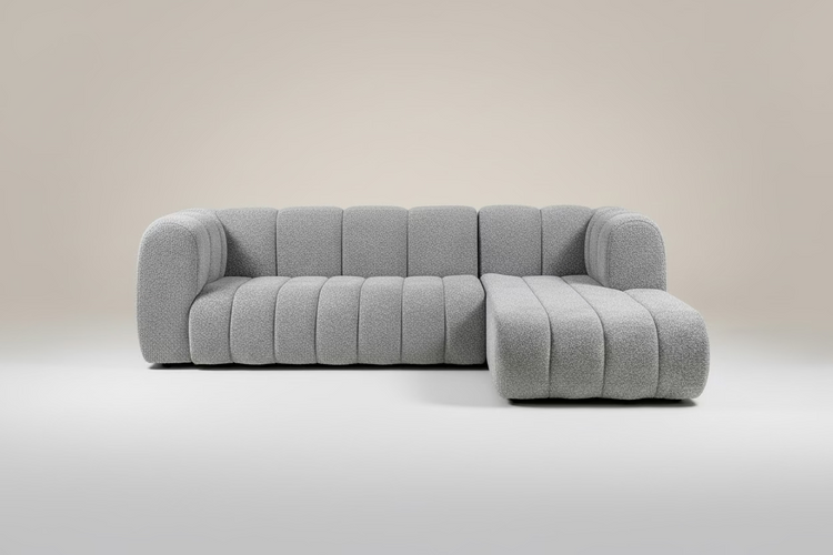 Gray textured sectional sofa in a showroom setting with tables and other furniture.