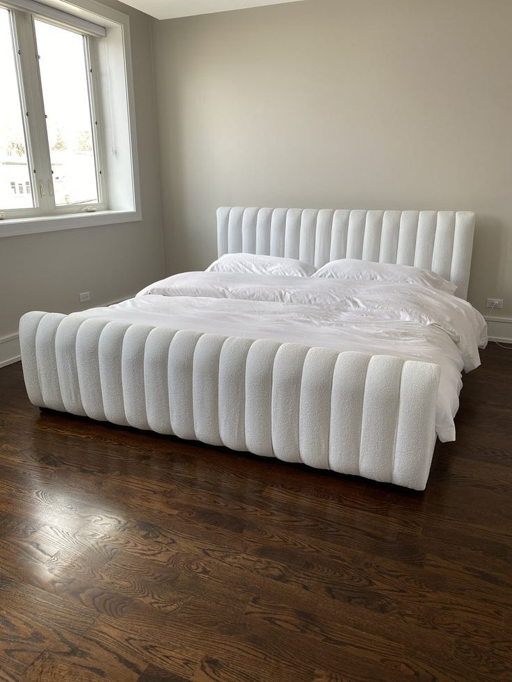 Angelic Panel Sleigh Bed in white velvet with channel-tufted frame in a bedroom